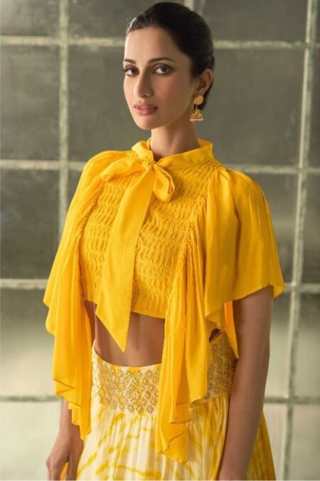 Yellow with white lace cropped top with cape-like overlay and a high-waisted skirt