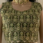 Cream colors with a dark green top and gold embroidery lehenga